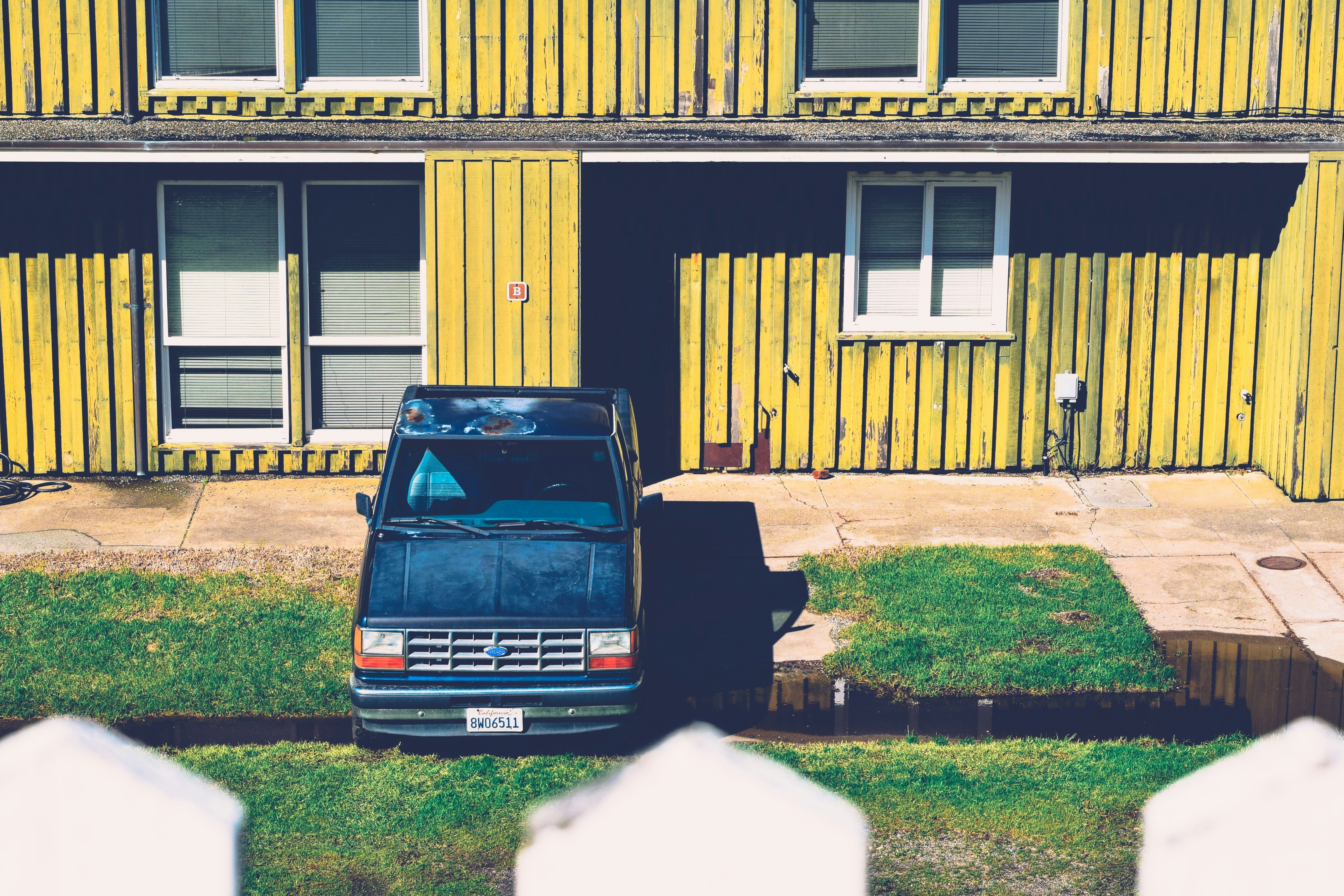 blue pickup truck packed on green grass